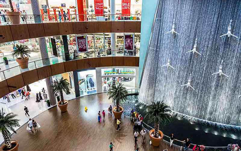 The stunning indoor waterfall at Dubai Mall, a must-see attraction featuring diving statues in a breathtaking setting.