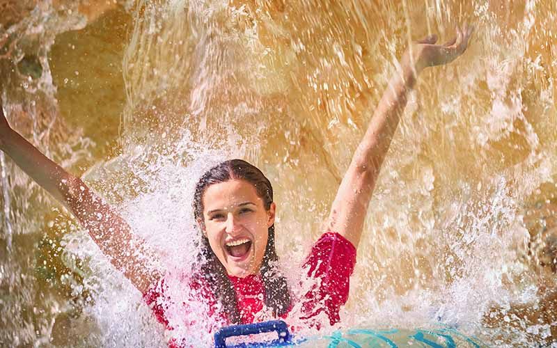 Woman enjoying a refreshing water splash at Aquaventure Waterpark, Dubai Woman enjoying a refreshing water splash at Aquaventure Waterpark, Dubai